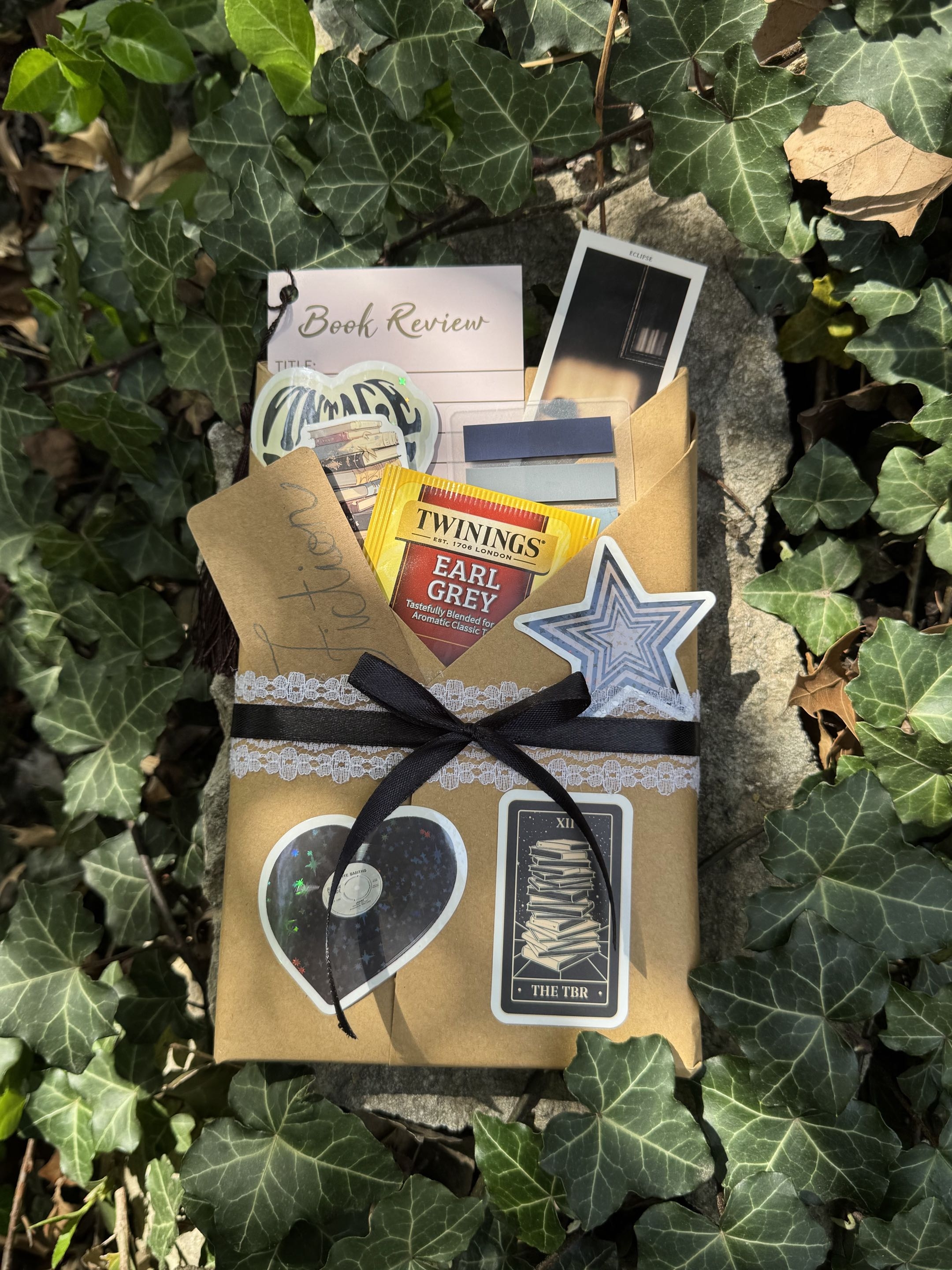Wrapped mystery book package styled with tea, bookmarks, and review notes